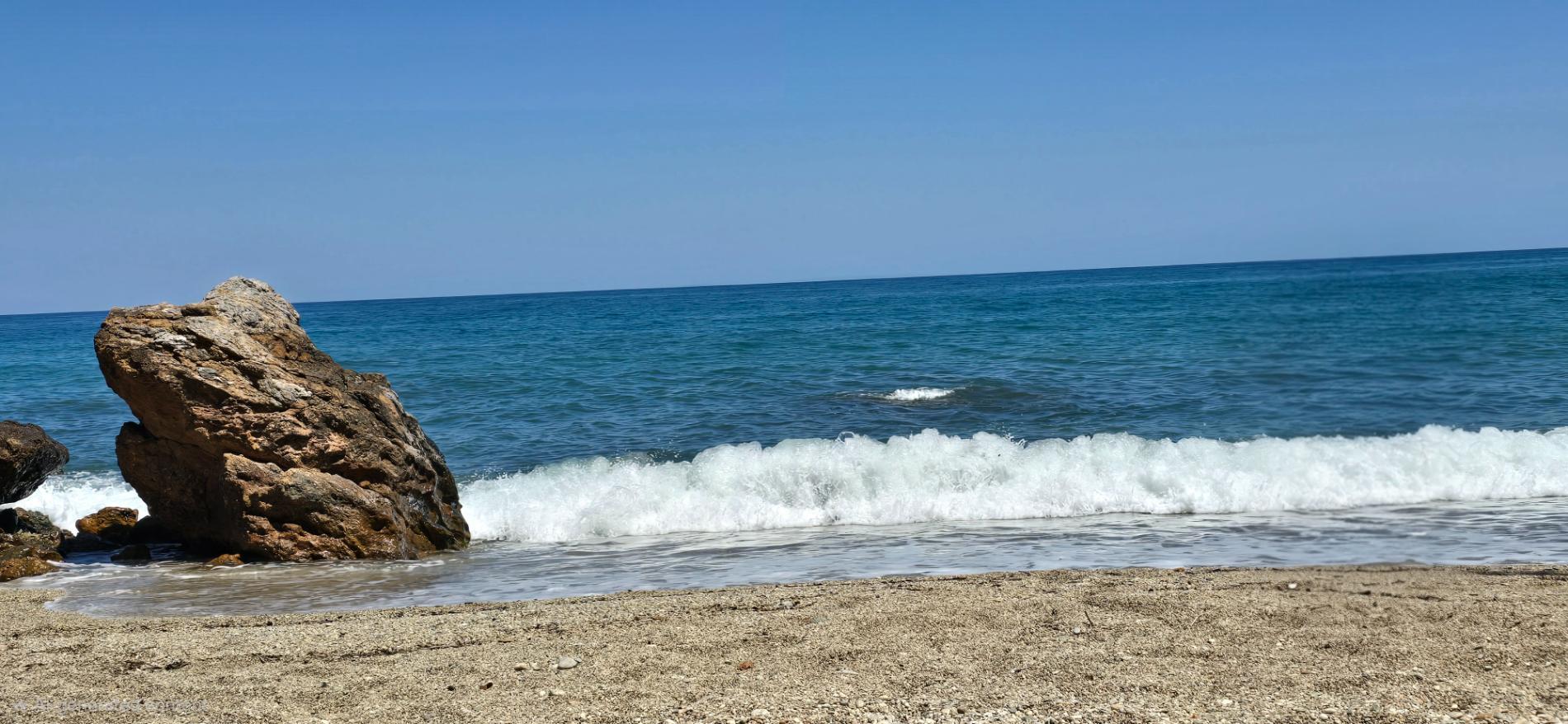 Foto av Pigadi Beach omgiven av klippor